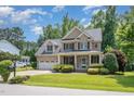 Handsome brick home featuring a two-car garage, covered entry, and lush green landscaping at 7336 Capulin Crest Dr, Apex, NC 27539