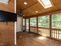 This sunroom features a wood paneled wall, a skylight, and many windows at 102 Sanair Ct, Apex, NC 27502