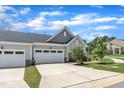 Spacious two car garage with white doors and concrete driveway framed by a well manicured lawn at 1021 Shellbank Dr, Durham, NC 27703