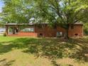 Backyard view of brick home with covered patio, perfect for outdoor entertaining and relaxation at 1051 Old Us 421, Lillington, NC 27546