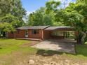 Brick ranch-style home with a covered carport and a spacious front yard, perfect for families at 1051 Old Us 421, Lillington, NC 27546