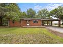 Charming brick ranch home featuring a covered carport, front yard, and traditional design elements at 1051 Old Us 421, Lillington, NC 27546