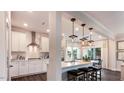 Modern kitchen featuring white cabinets, stainless steel appliances, pendant lighting, and a breakfast bar with stools at 1240 Hazelnut Ridge Ln, Knightdale, NC 27545
