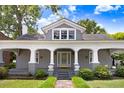Classic home featuring a covered front porch with elegant columns, manicured lawn, and inviting entryway creating a warm welcome at 125 W Pine St, Pine Level, NC 27568