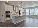 Modern kitchen features a central island, stainless steel appliances, and sleek white cabinetry at 2203 Lambert Rd # 67, Cary, NC 27519