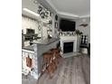 Open-concept kitchen with a breakfast bar and stools flowing into a living area with a fireplace at 2452 Bay Harbor Dr, Raleigh, NC 27604