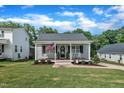 Inviting single-story home with a quaint front porch, rocking chairs, and manicured front lawn at 267 Ashley Woods Ct, Clayton, NC 27527