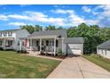 Attractive home with covered front porch, American flag and well-maintained lawn and landscape at 267 Ashley Woods Ct, Clayton, NC 27527