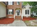 Inviting front entrance with brick steps, white railings, and a decorative arched doorway at 3020 Woods Walk Way, Rocky Mount, NC 27804