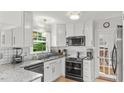 Well-equipped kitchen with white cabinetry, stainless steel appliances, and tile backsplash at 3070 Cameron Dr, Henderson, NC 27536