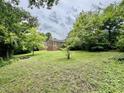 Spacious backyard featuring mature trees and a fire pit at 405 Foster Ln, Burlington, NC 27215