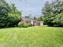 Quaint brick home with large front lawn, decorative shutters and detached garage at 405 Foster Ln, Burlington, NC 27215