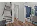Bright hallway with hardwood floors, white trim, access to the dining room, and an adjacent staircase at 415 1St St, Apex, NC 27502