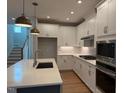 This modern kitchen features white cabinets, stainless steel appliances, and a quartz countertop island at 64 Rainfall Dr, Pittsboro, NC 27312