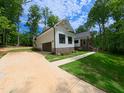 Charming home with driveway leading to a garage and entry, brick accents, and timber gable decoration at 690 Oaks Lane Rd, Timberlake, NC 27583