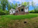 Charming home with brick accents and timber gable decoration sits among mature trees on a manicured, sloping lawn at 690 Oaks Lane Rd, Timberlake, NC 27583