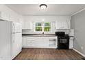 An updated kitchen with white cabinets and modern appliances creates a clean and efficient cooking space at 7924 Knightdale Blvd, Knightdale, NC 27545