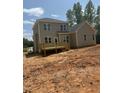 The back of the house has gray siding and a wooden deck with stairs descending to the yard at 80 Copper Penny Rd, Zebulon, NC 27597