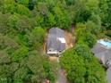An aerial view of a home with a newly installed roof surrounded by lush trees at 8011 Old Trail Dr, Durham, NC 27712