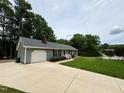 Charming single-story home with an attached garage, driveway, and a well-maintained lawn at 100 Honeysuckle Ln, Cary, NC 27513