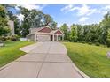 Wide shot of a charming home showcasing a long driveway and verdant landscaping at 100 Pronghorn Deer Ct, Garner, NC 27529