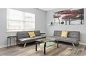 Bright living room with two gray sofas, glass coffee table, and large window at 1002 Willow Dr # Apt 107, Chapel Hill, NC 27514