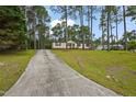 A long driveway leads to this charming home with a spacious front lawn at 101 Hunter Fld, Sanford, NC 27332