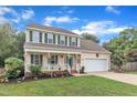 Lovely two-story house with a covered front porch, attached garage, and beautifully landscaped front yard at 102 Lake Meadow Dr, Apex, NC 27502