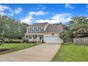 Traditional two-story home with a covered front porch, attached garage, and mature landscaping at 102 Lake Meadow Dr, Apex, NC 27502