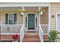Inviting front porch with hanging flower baskets, white railings, and a welcoming front door at 102 Lake Meadow Dr, Apex, NC 27502
