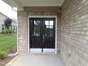 Stylish black double front door with glass panels and brick surround offers a welcoming entry at 1042 Tulloch Court Ct # 213, Burlington, NC 27215