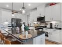 Modern kitchen features a kitchen island, granite countertops, and stainless steel appliances at 1104 Briar Gate Dr, Holly Springs, NC 27540