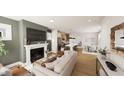 Open-concept living space with fireplace, sleek furniture, adjacent kitchen, and a dining area at 111 Weavers Grv Dr, Chapel Hill, NC 27514