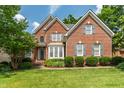 Stunning brick residence boasts manicured landscaping, gray shutters, and a welcoming front entrance at 1149 The Preserve Trl, Chapel Hill, NC 27517