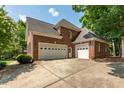 Spacious three-car garage showcases brick construction and ample parking space with a large driveway at 1149 The Preserve Trl, Chapel Hill, NC 27517