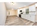 Bright kitchen featuring white cabinets, stainless steel appliances, and modern flooring at 121 Lena Ct, Burlington, NC 27217