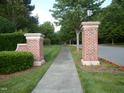 Inviting entrance to the community with brick pillars, manicured landscaping, and a peaceful walkway at 126 Kipling Dr, Oxford, NC 27565