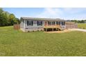 Single-story home with a cozy front porch and a large grassy yard at 130 Ruby Trl, Roxboro, NC 27574