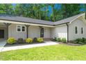The front of a house features a well-kept lawn and an inviting entrance with a dark front door and accents at 1308 Broken Branch Ct, Raleigh, NC 27610