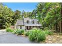 Charming home featuring a covered front porch and lush landscaping surrounded by mature trees in wooded setting at 139 Trillium Pl, Chapel Hill, NC 27517