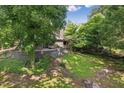 Scenic backyard featuring lush greenery, a stone wall, and mature trees at 1846 Hammond St, Rocky Mount, NC 27803