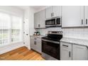 Well-lit kitchen boasting stainless steel appliances, granite countertops, and hardwood flooring at 2001 Turtle Point Dr, Raleigh, NC 27604