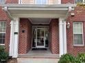 Close-up of a brick building entrance with white columns supporting the roof at 211 Providence Glen, Chapel Hill, NC 27514