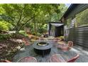 Inviting backyard area featuring a fire pit with chairs, set against a backdrop of mature trees and a wooden deck at 2306 Damascus Church Rd, Chapel Hill, NC 27516