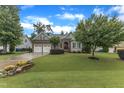 A home with a beautiful green lawn, landscaping, and a two-car garage at 3111 Virginia Pine Ln, Apex, NC 27539