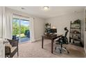 Bright and functional office space with a desk, shelving, and a sliding glass door to the outside at 336 Skymont Dr, Holly Springs, NC 27540