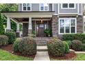 Inviting front porch featuring stone accents, a dark wood door, and well-maintained landscaping at 425 Morrison Ave, Raleigh, NC 27608