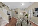 Elegant dining area with a glass-top table set on a patterned rug, adjacent to the kitchen and staircase at 6131 Summerpointe Pl # 101, Raleigh, NC 27606