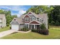 Charming two-story home featuring a lush lawn, colorful landscaping, and a welcoming entrance at 112 Pearsall Farm Ln, Clayton, NC 27527