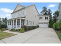 Beautiful home with a long driveway leading to a two-car garage, surrounded by lush landscaping at 113 Market Cross Ct, Holly Springs, NC 27540